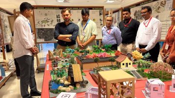 image of ceo of Thakur School of Architecture & Planning looking at a scale model